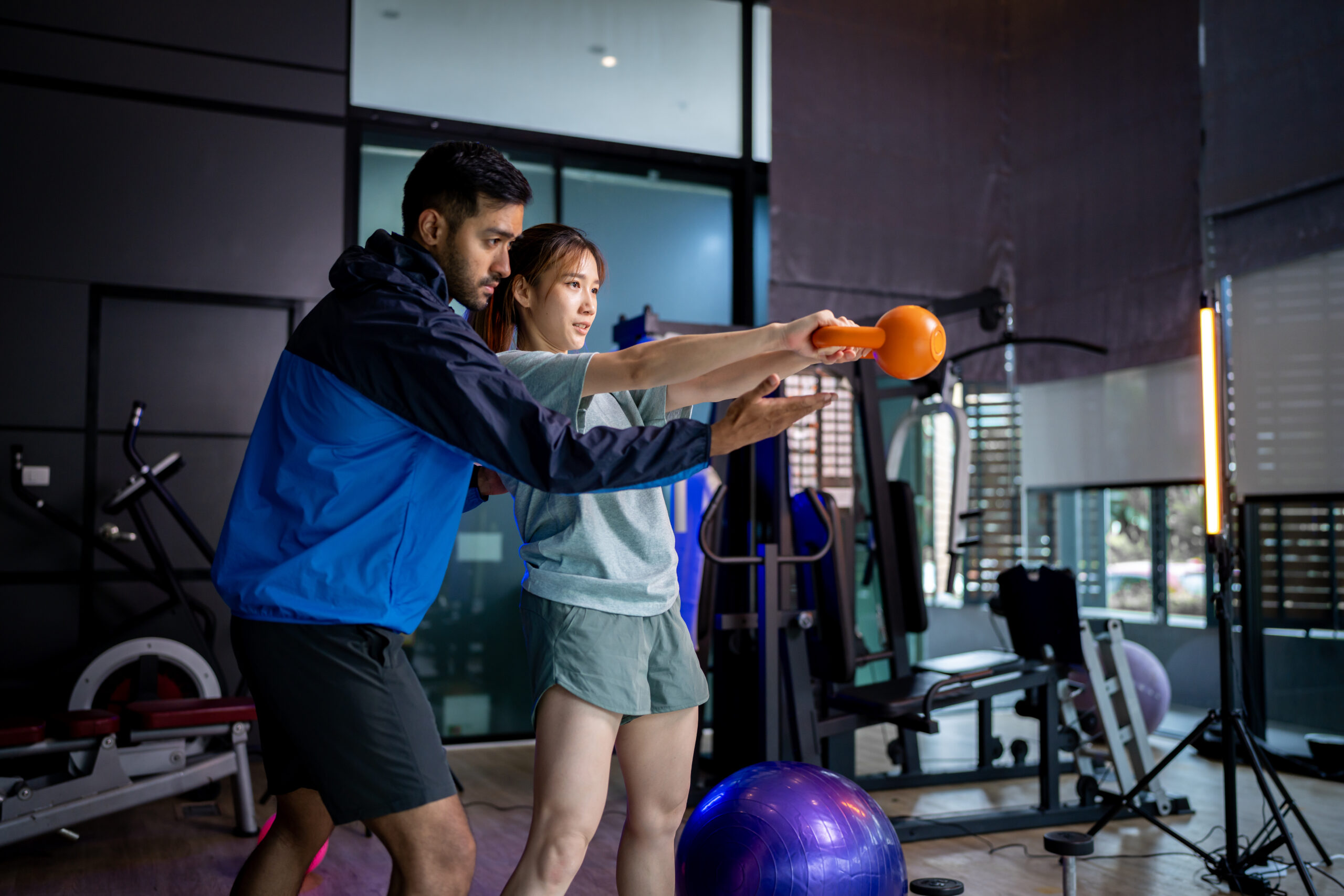 Asian man and woman working out, one is a trainer, the other is an exerciser